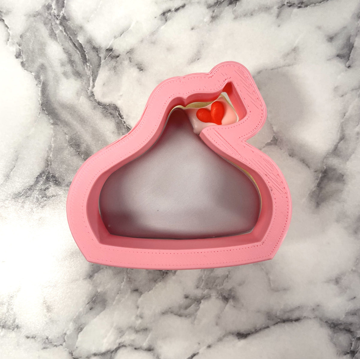 Mini chocolate kiss cookie cutter in pink silicone with a small red heart detail inside the opening
