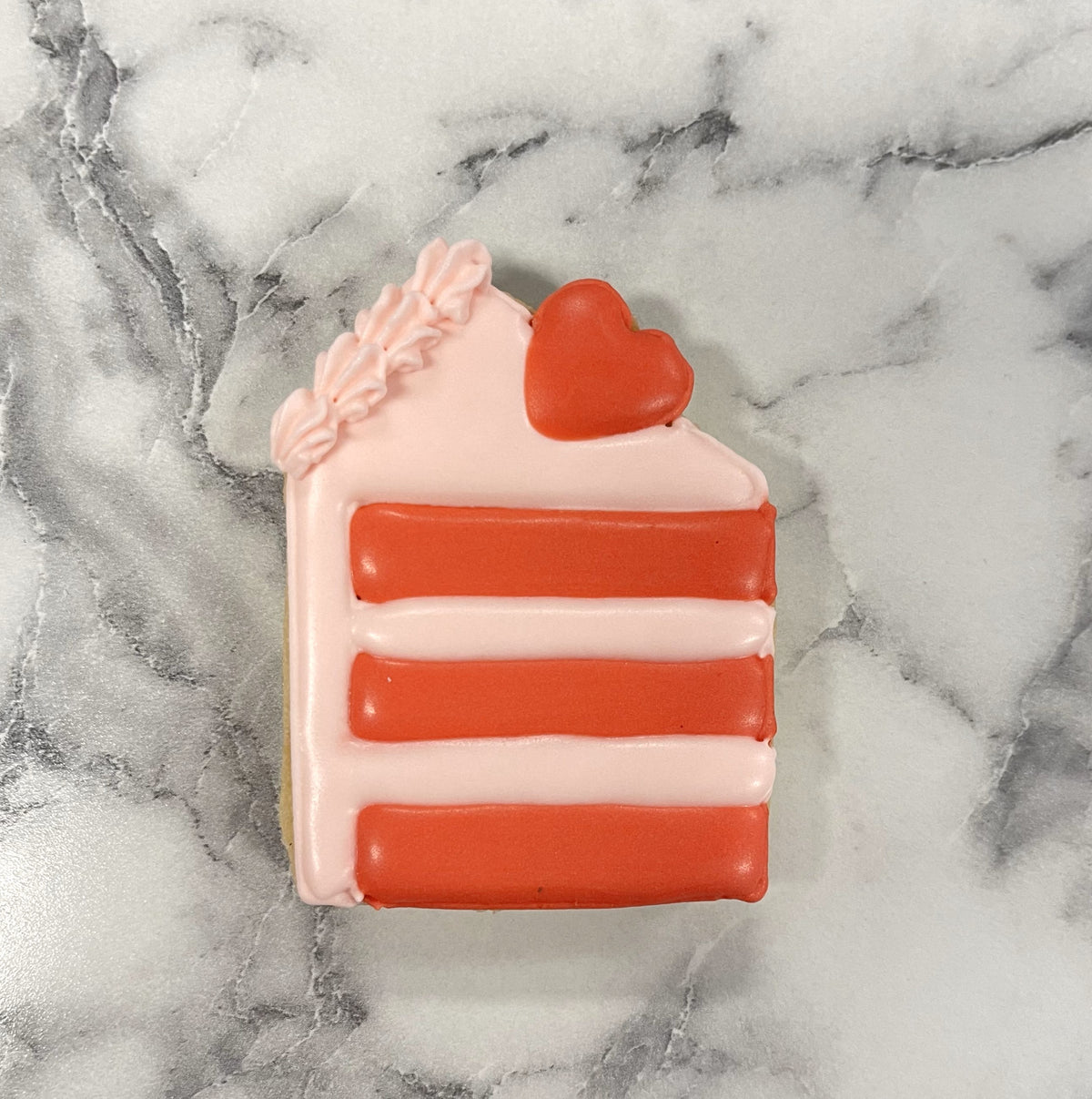 Mini tall cake slice cookie cutter keychain in pink and red with heart detail shaped like a layered cake slice