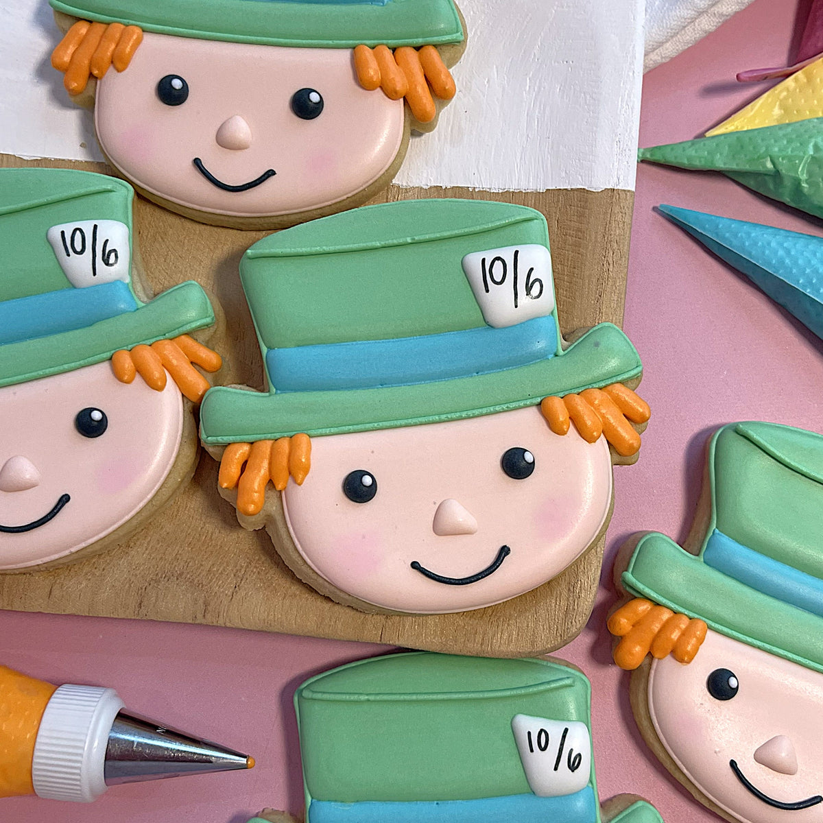 Alice in wonderland cookie cutter bundle with green and blue top hat cookies featuring orange hair and pink faces