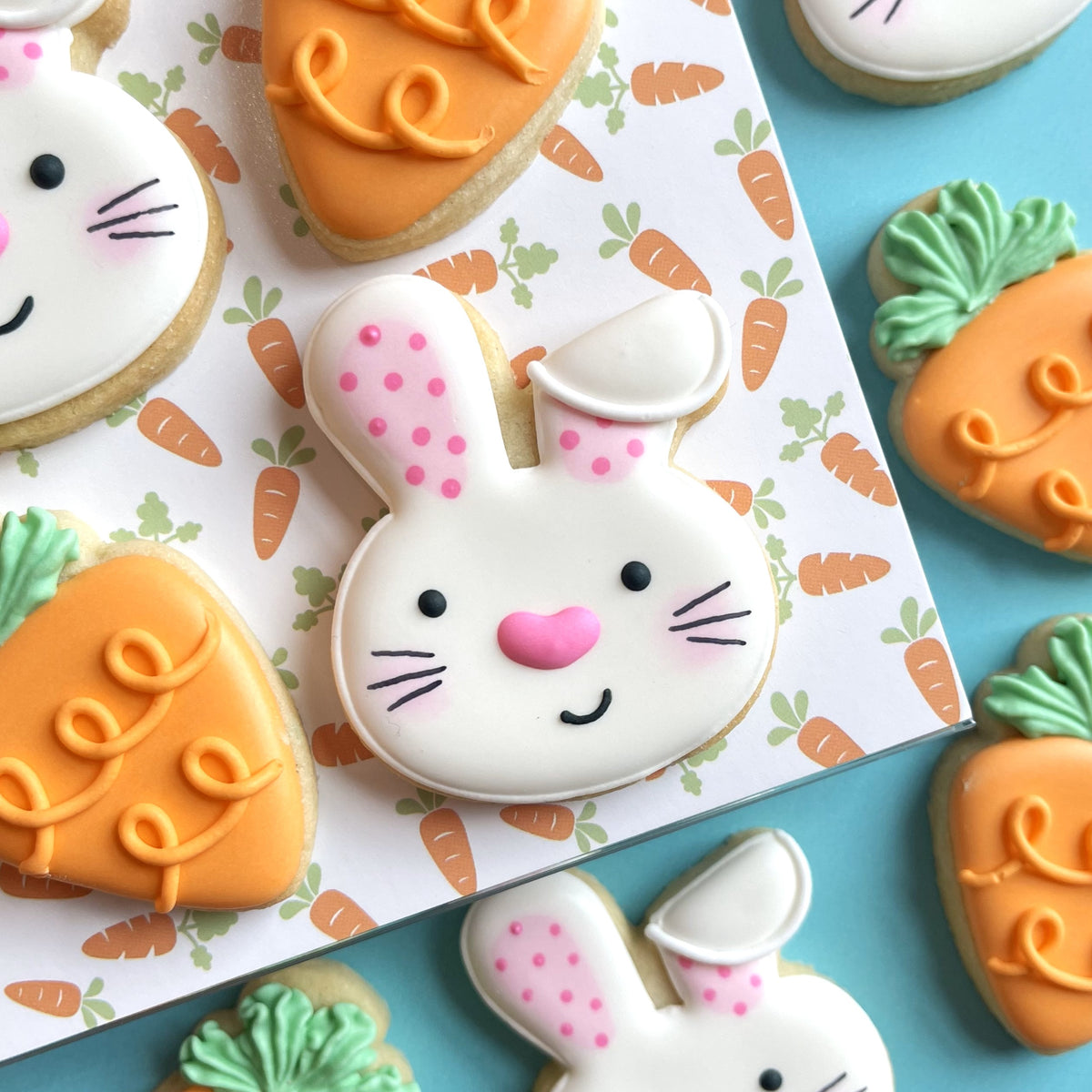 A white bunny-shaped cookie with pink polka-dotted ears and nose made using mini easter cookie cutter bundle