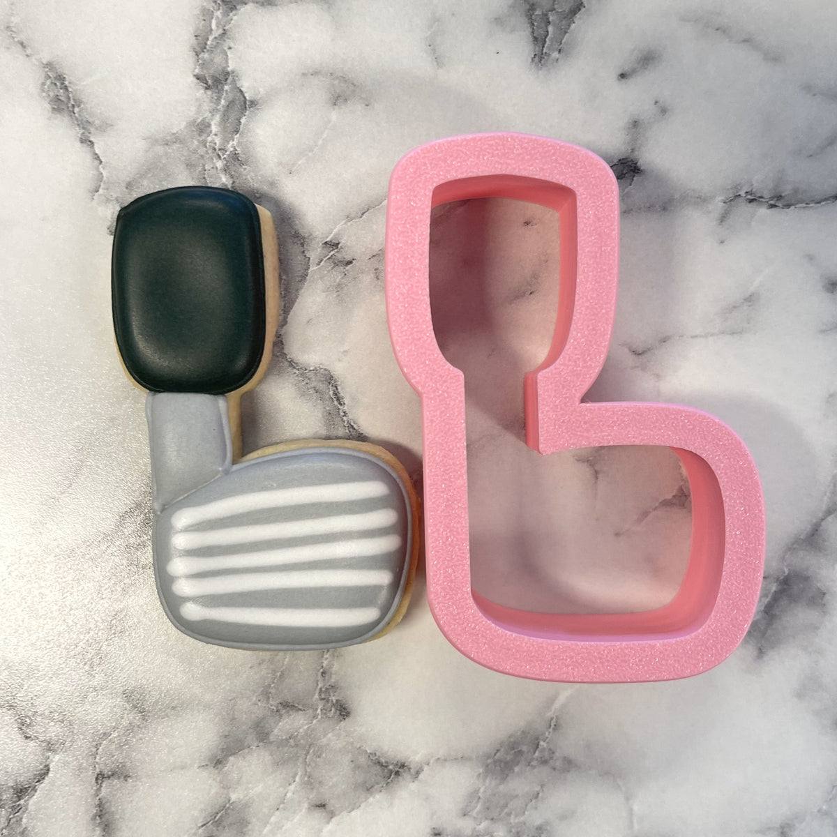 Pink glittery metal cookie cutter shaped like a mini golf club for themed baking and decorating