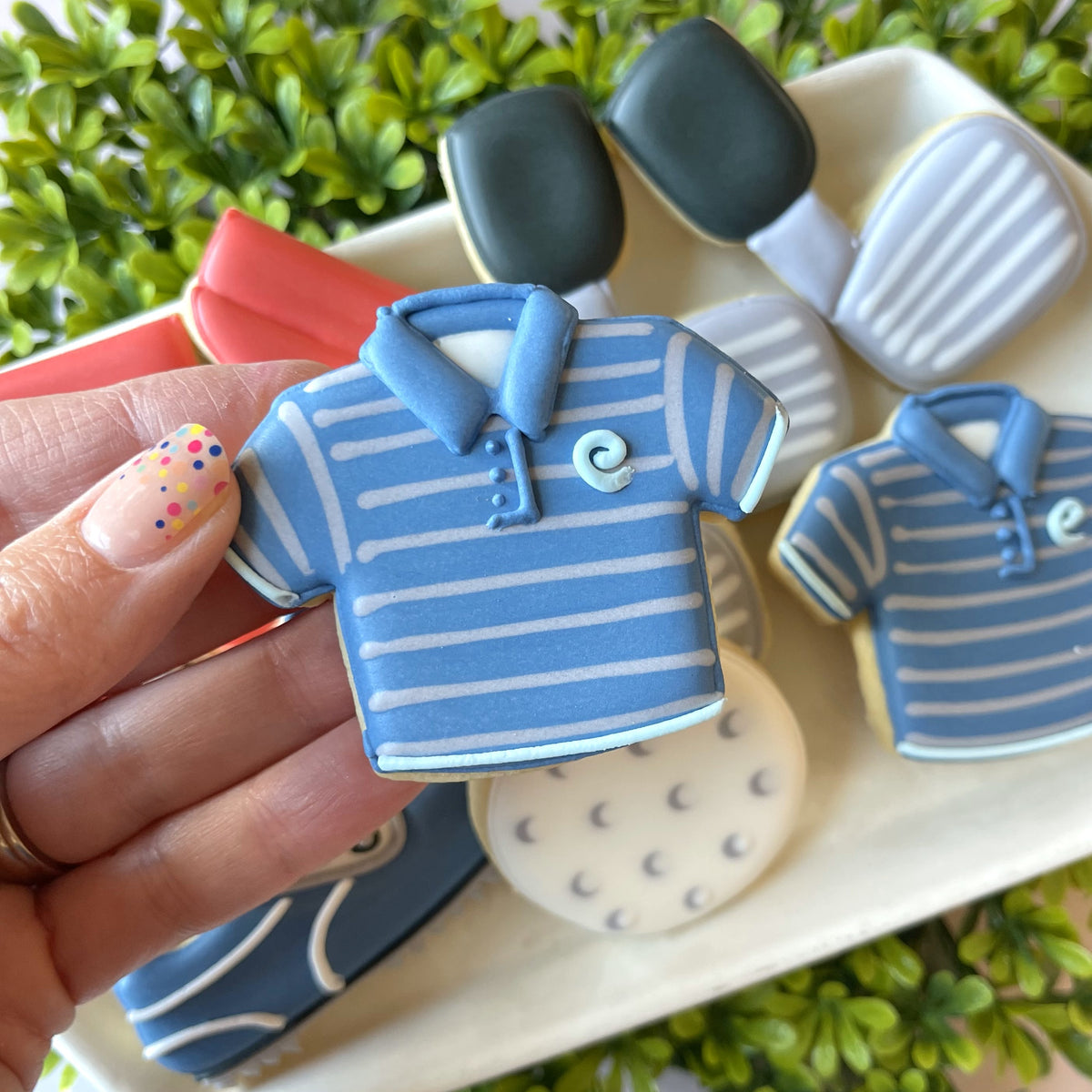 Mini golf shirt cookie cutter shaped like a blue and white striped polo shirt with light blue collar and spiral logo