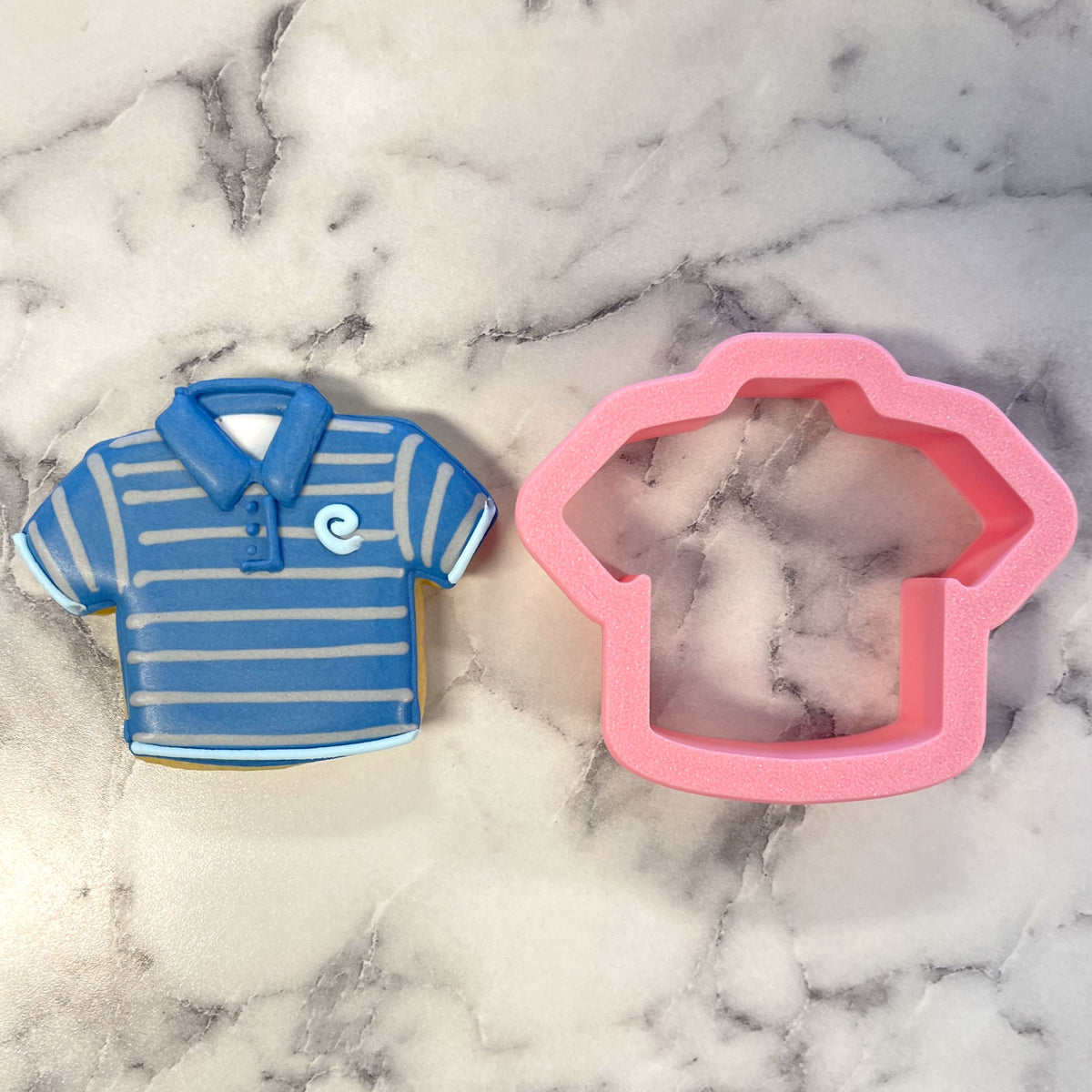 Mini golf shirt cookie cutter with a blue and white striped polo shirt cookie and a pink silicone mold
