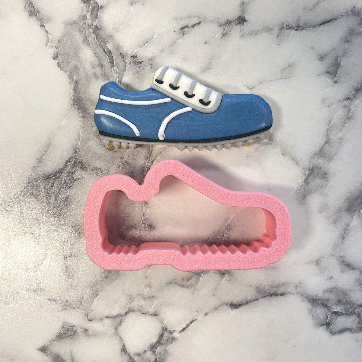 Mini golf shoes cookie cutter with blue and white metal sneaker shape and pink silicone mold for baking and crafts