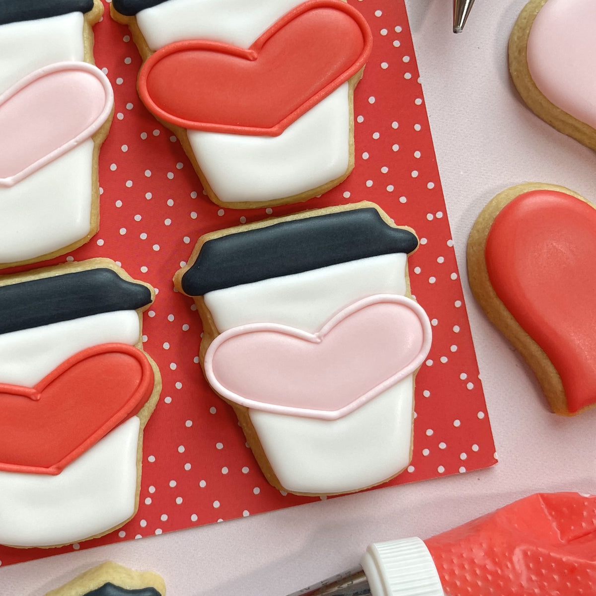 Mini latte heart cookie cutter with a heart-shaped cookie decorated with smooth white icing and pink heart design