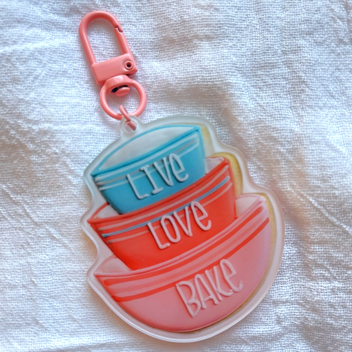 Stacked baking bowl keychain in pink orange and blue translucent acrylic with live love bake embossed bowls