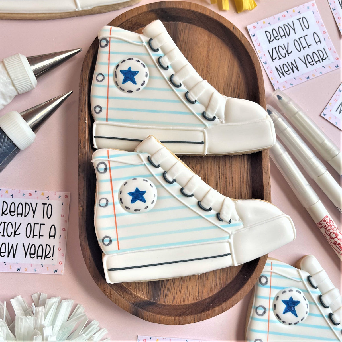 High top sneaker cookie cutter featuring white sugar cookie design with light blue red striped notebook paper and navy star emblem