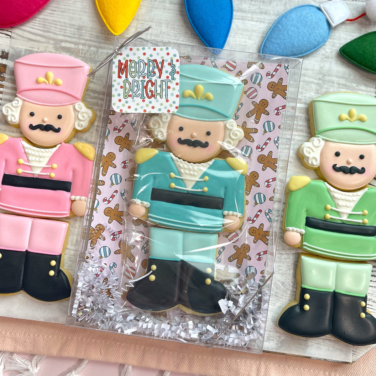 A festive turquoise nutcracker cookie with matching hat black boots and gold buttons made with nutcracker 3-in-1 cutter