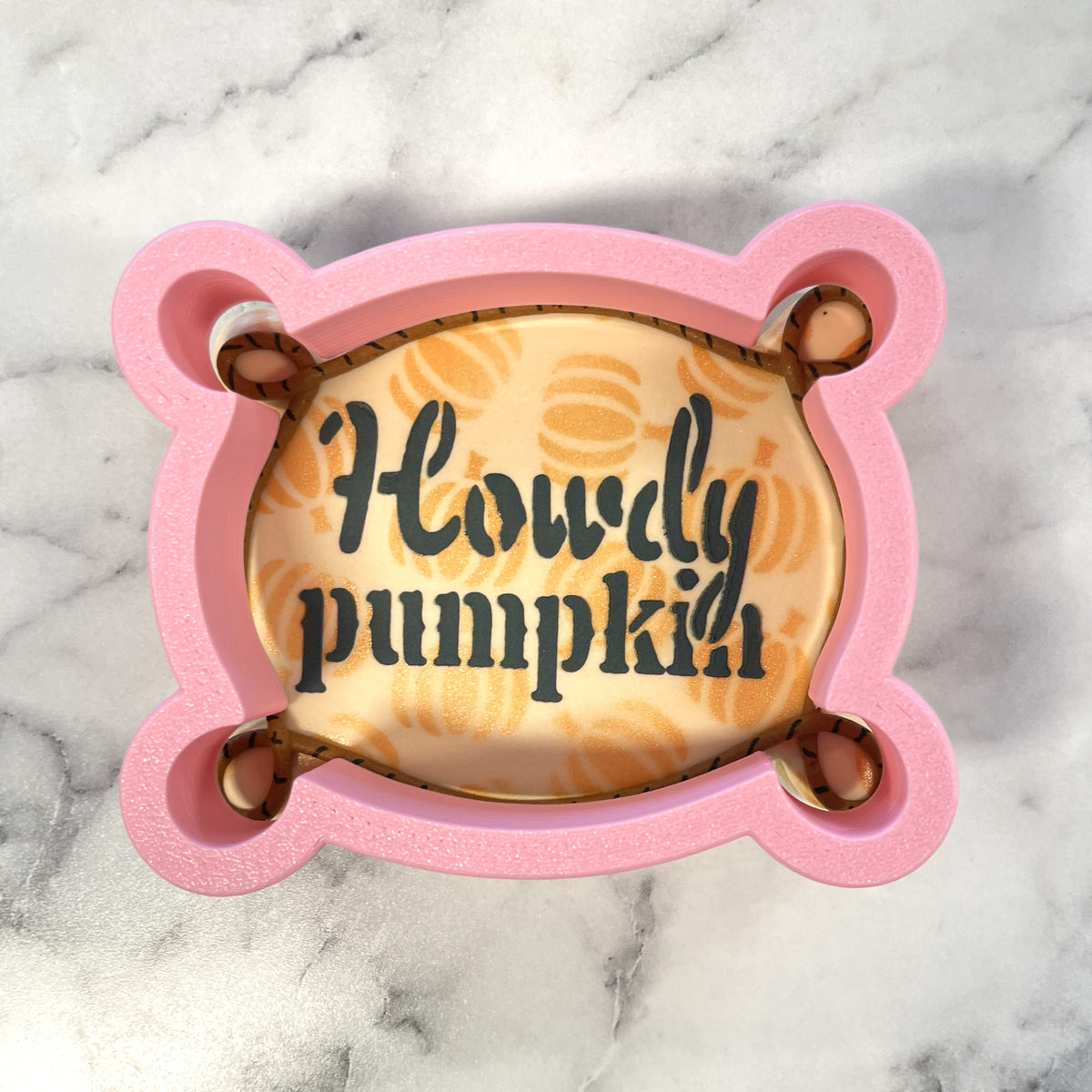 Pink silicone pumpkin-shaped western plaque cookie cutter with howdy pumpkin text and orange pumpkin stencil pattern