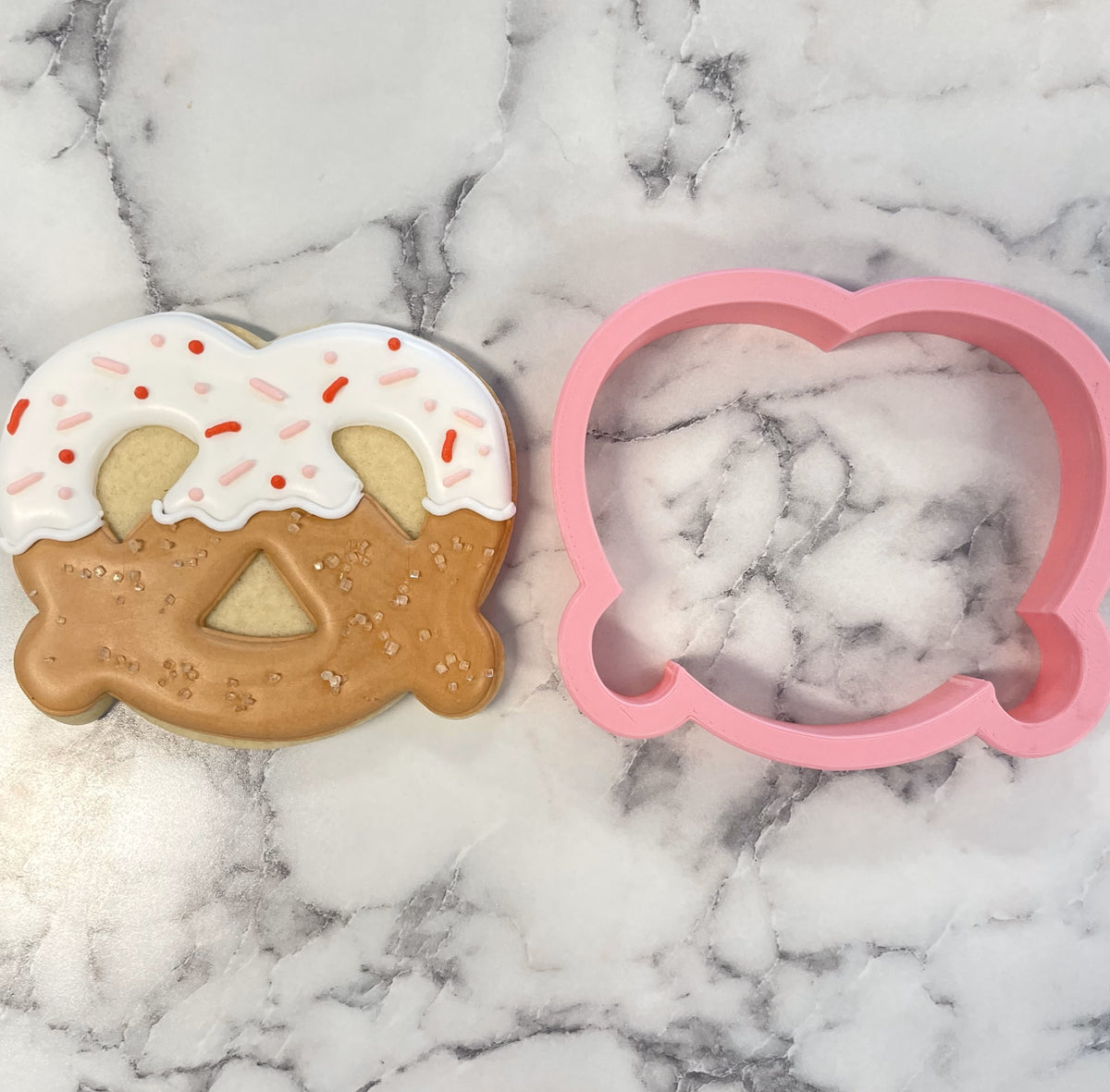 Pink plastic pretzel cookie cutter designed for shaping pretzel-shaped cookies with durable plastic material