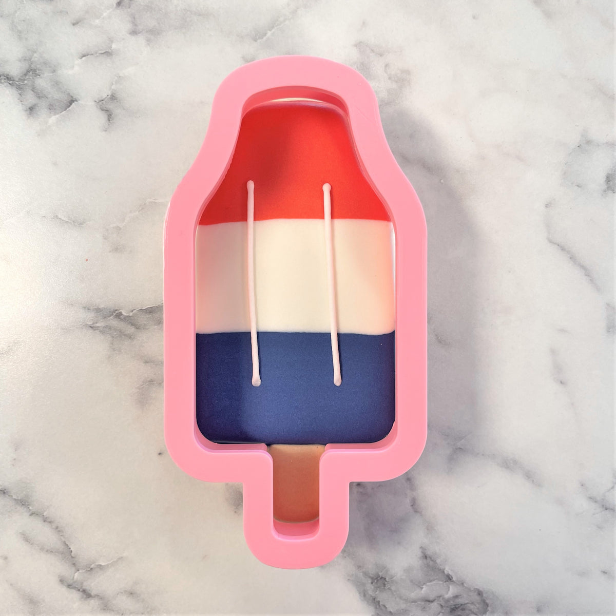 Pink silicone popsicle mold with red white and blue layered interior for rocket pop flour box club cookie cutter
