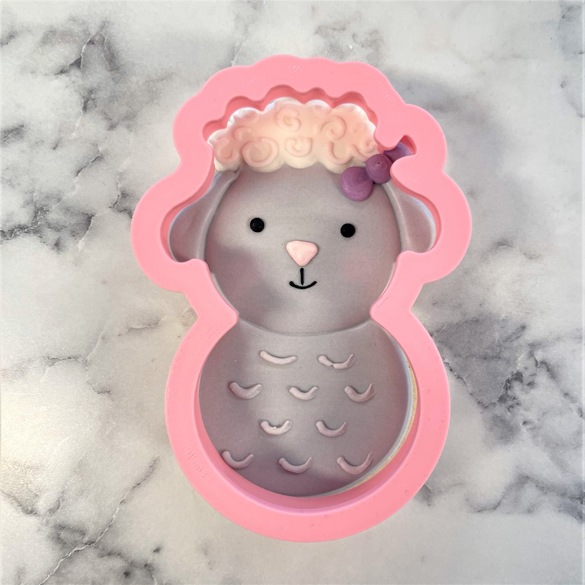 Pink silicone lamb-shaped baking mold with gray interior white curly wool and purple bow for lamb roly poly cookie cutter