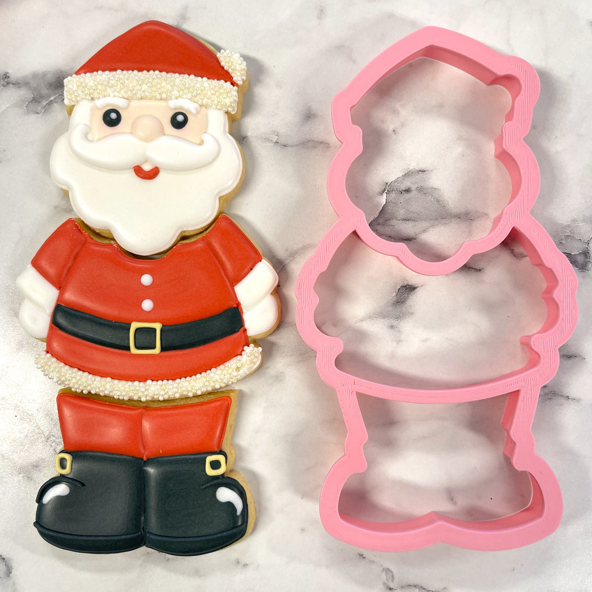 A festive red and white santa claus cookie decorated with icing made using the santa 3-in-1 multi-cookie cutter