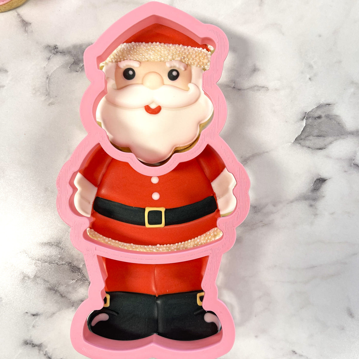 Pink silicone santa claus-shaped baking mold with red black details white beard and gold trim for multi-cookie cutter