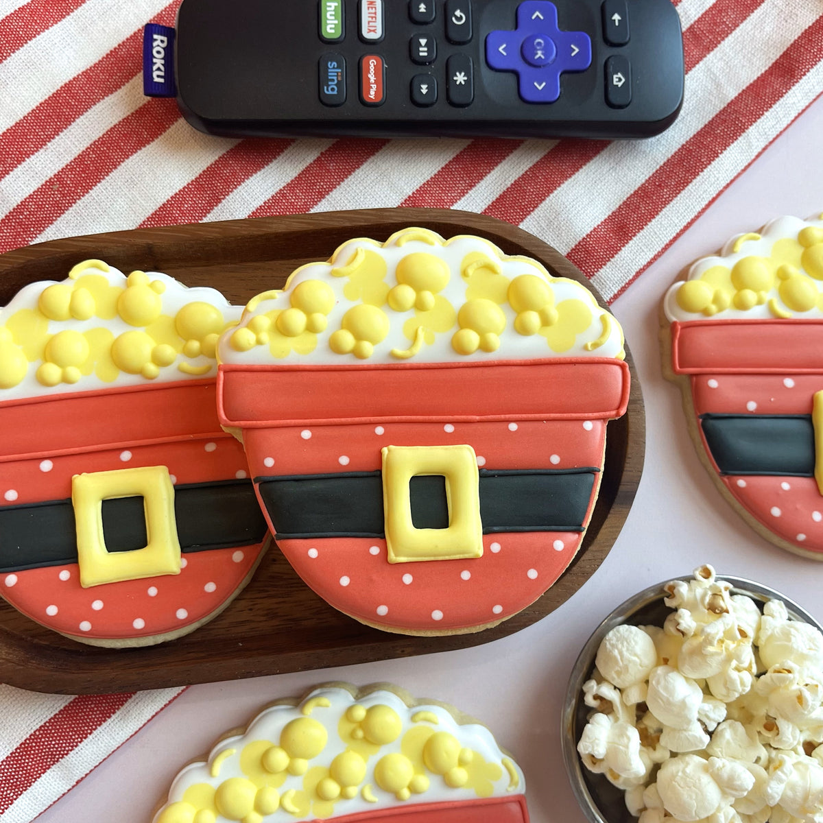 Santa popcorn bowl cookie cutter shaped cookies with red and white polka dots yellow icing popcorn and black belt detail