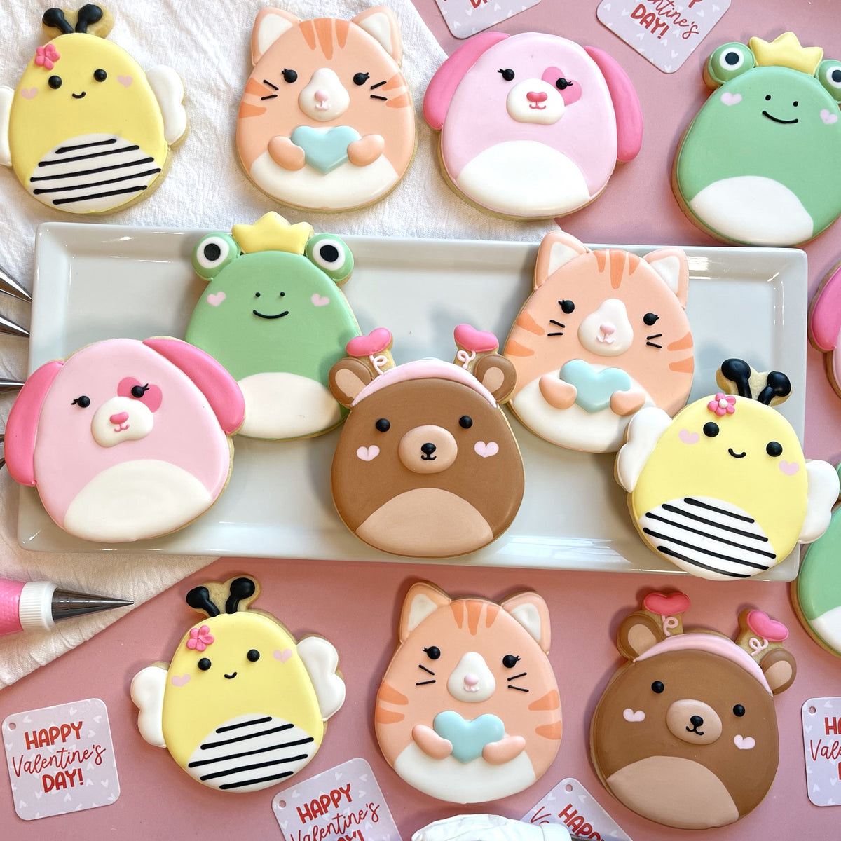 Pastel-colored intricately decorated sugar cookies shaped like cats bees frogs and bears from squishie valentine’s decorating kit