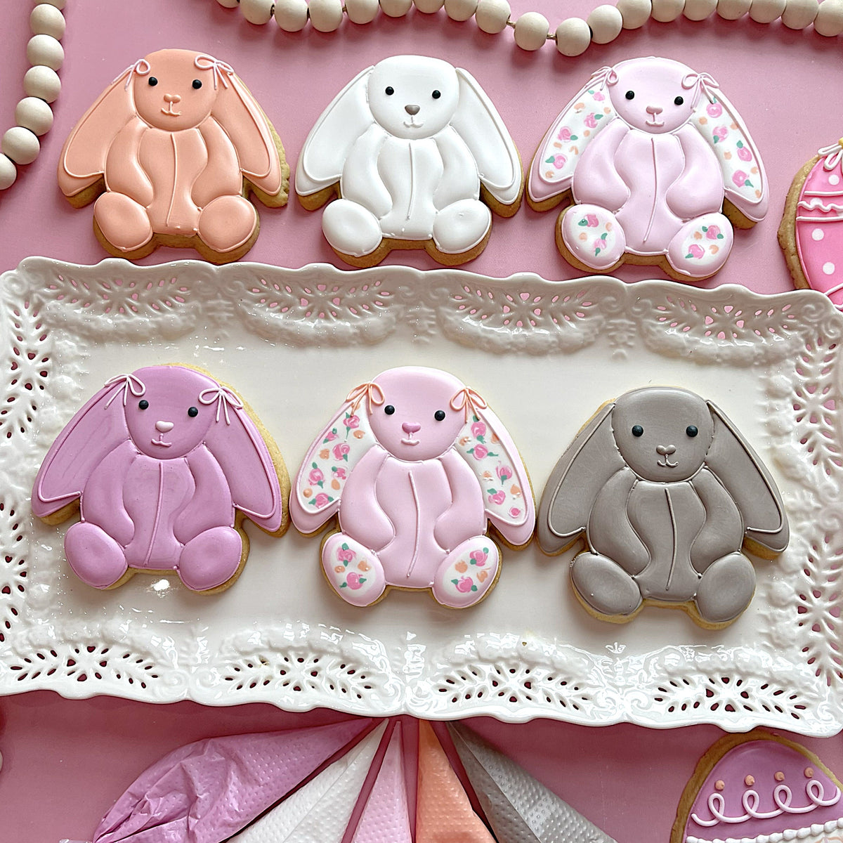 Pastel-colored stuffed bunny sugar cookies with delicate icing in peach white pink lavender and gray hues
