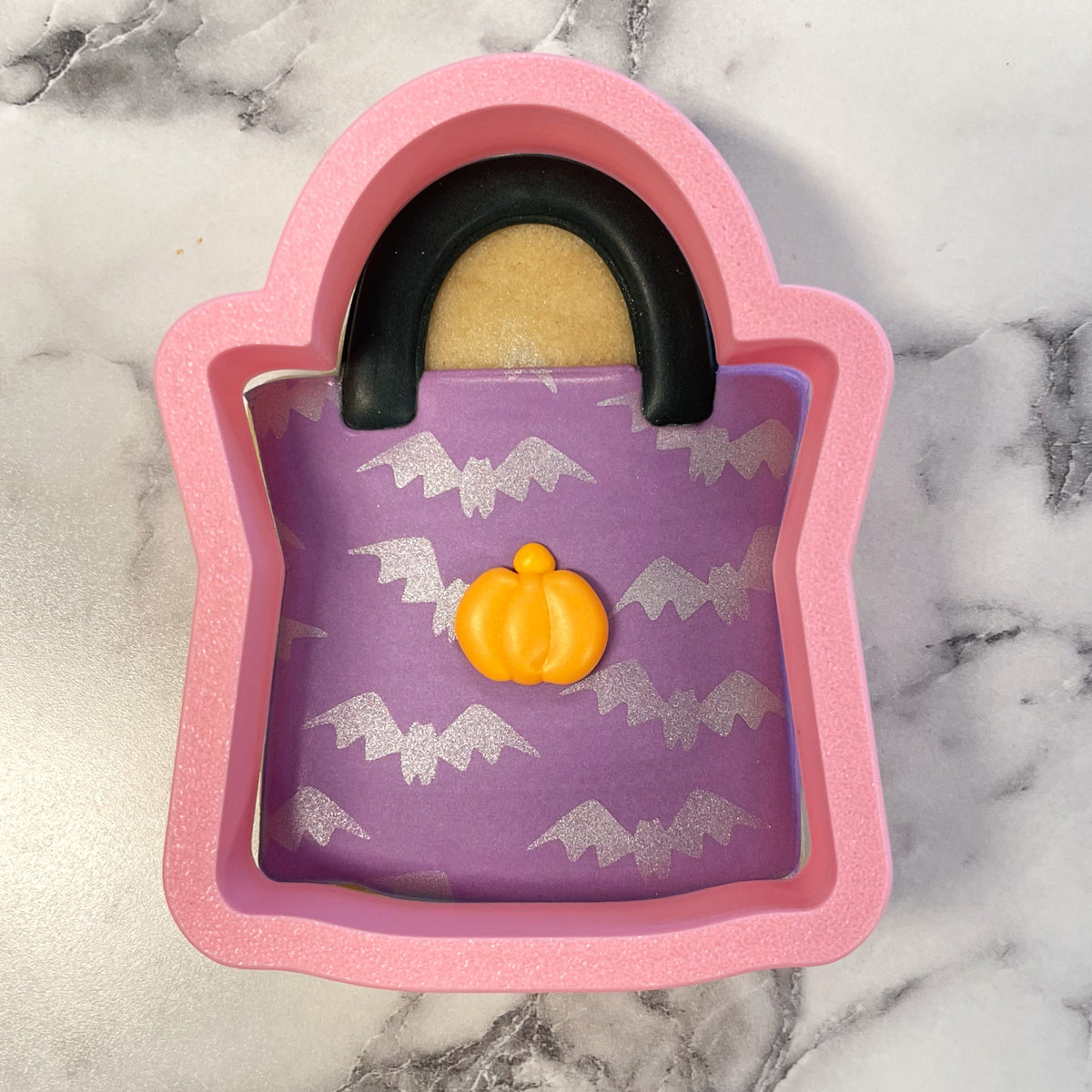 Pink silicone handbag-shaped treat bag flour box club cookie cutter with black handle purple interior and pumpkin charm