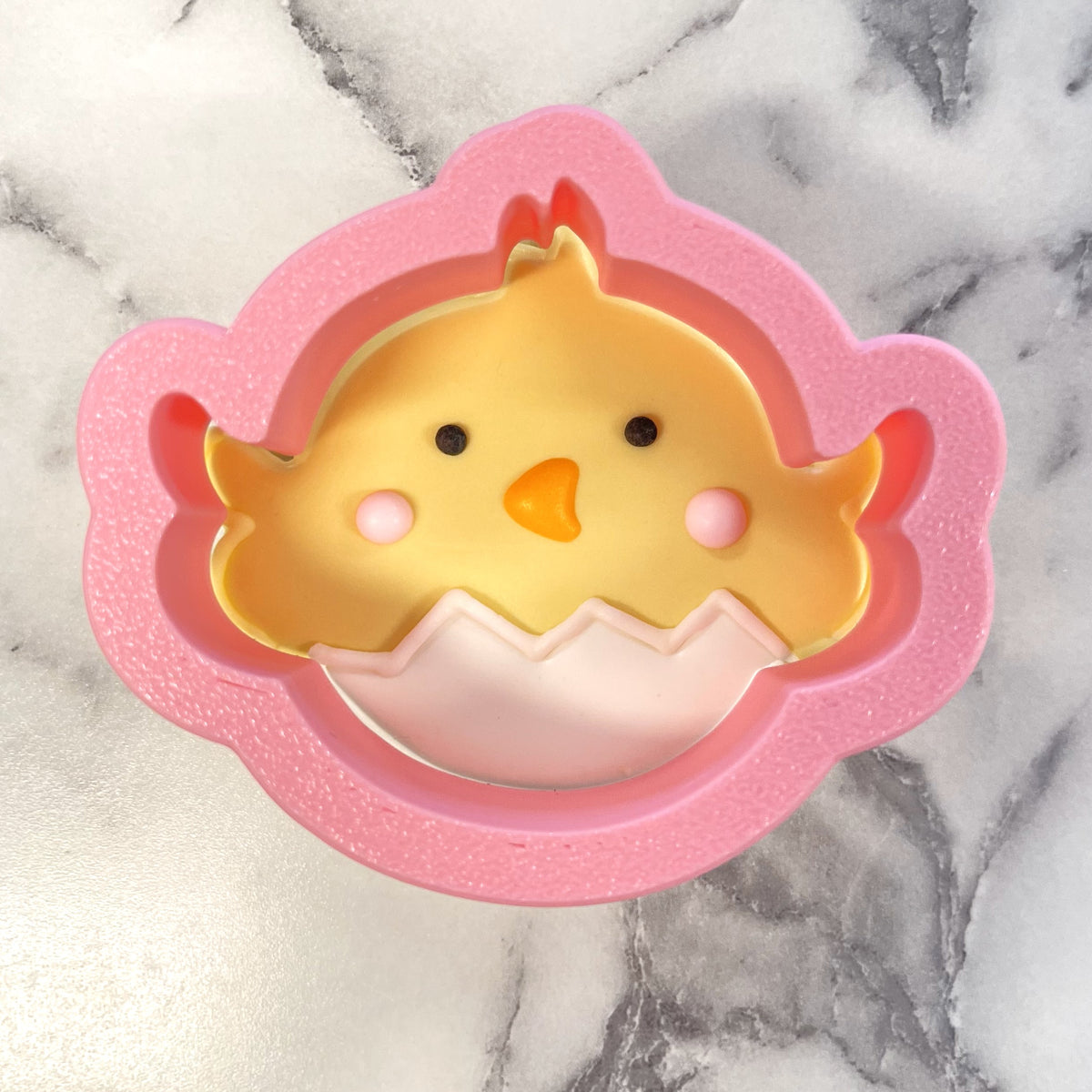 Mini tumbling chicks 2-cutter set featuring pink silicone chick-shaped cookie cutter with yellow chick in eggshell design