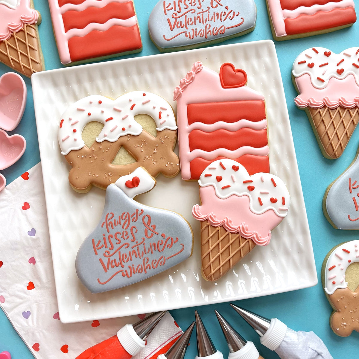 Chocolate Kiss Cookie Cutter shaped pink and white frosted ice cream cone cookie with red heart sprinkles