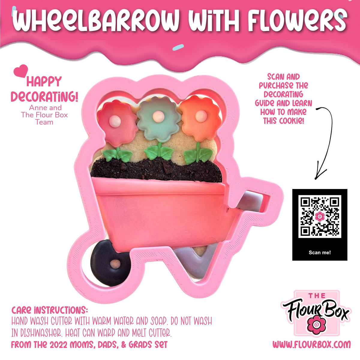 Pink plastic wheelbarrow cookie cutter with black wheels and three colorful flower-shaped cutouts for baking