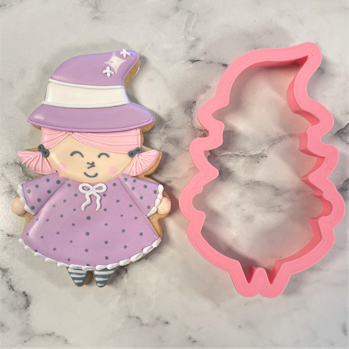 A pink silicone witch cookie cutter shaped like a witch hat for baking and decorating Halloween treats