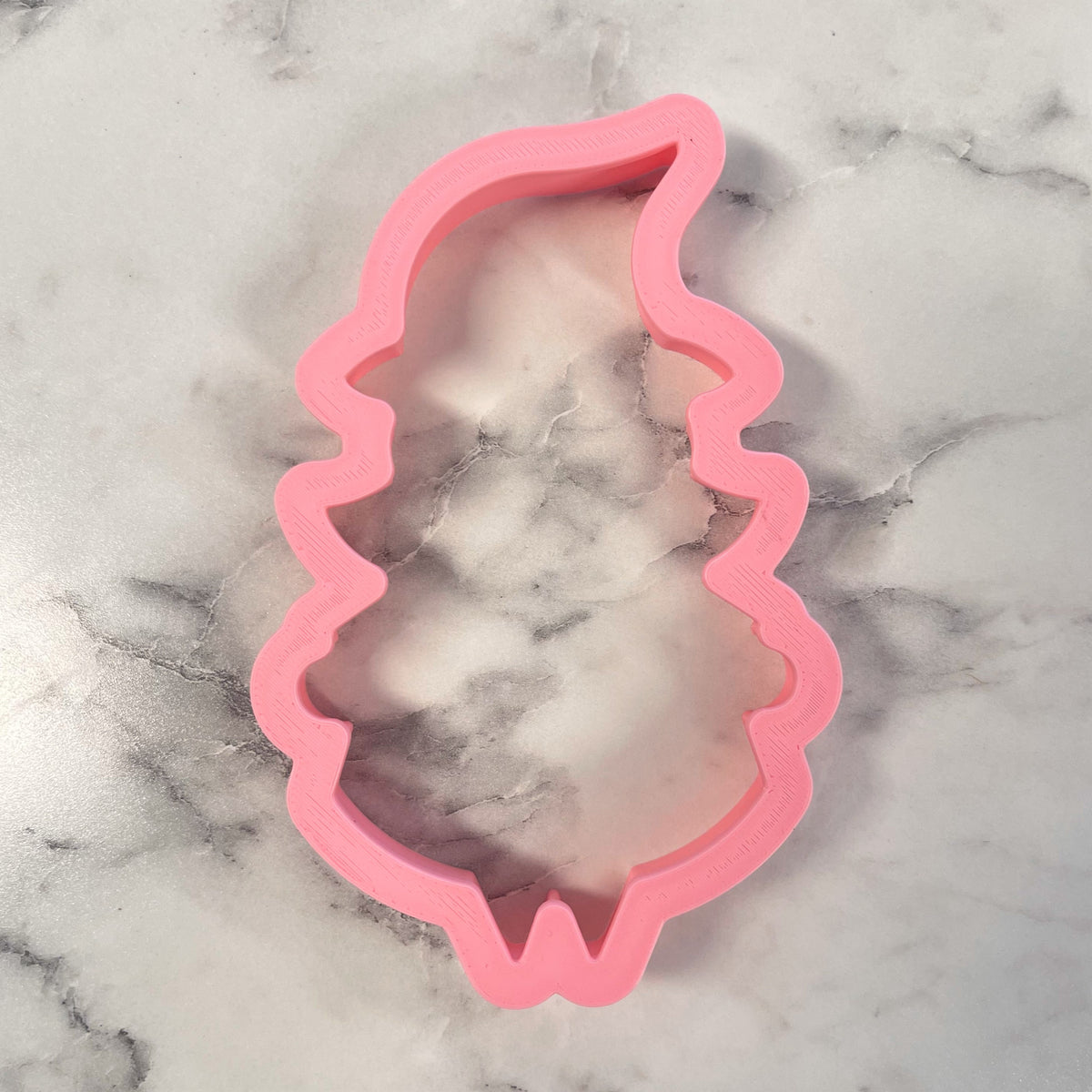 Pink plastic witch cookie cutter shaped like a witch’s hat for Halloween baking and cookie decorating