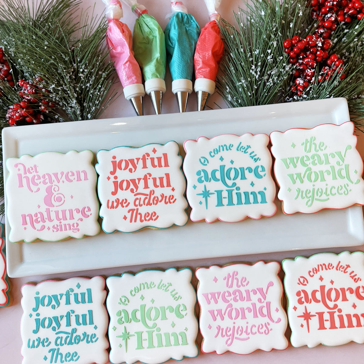 White frosted Christmas cookies decorated with colorful icing text and borders from Christmas Carol stencil bundle