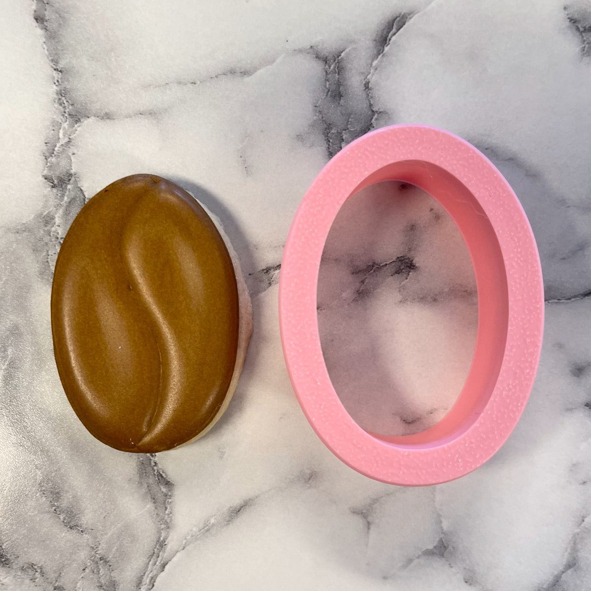 Pink silicone oval soap mold designed as a mini coffee bean cookie cutter for baking and crafting use