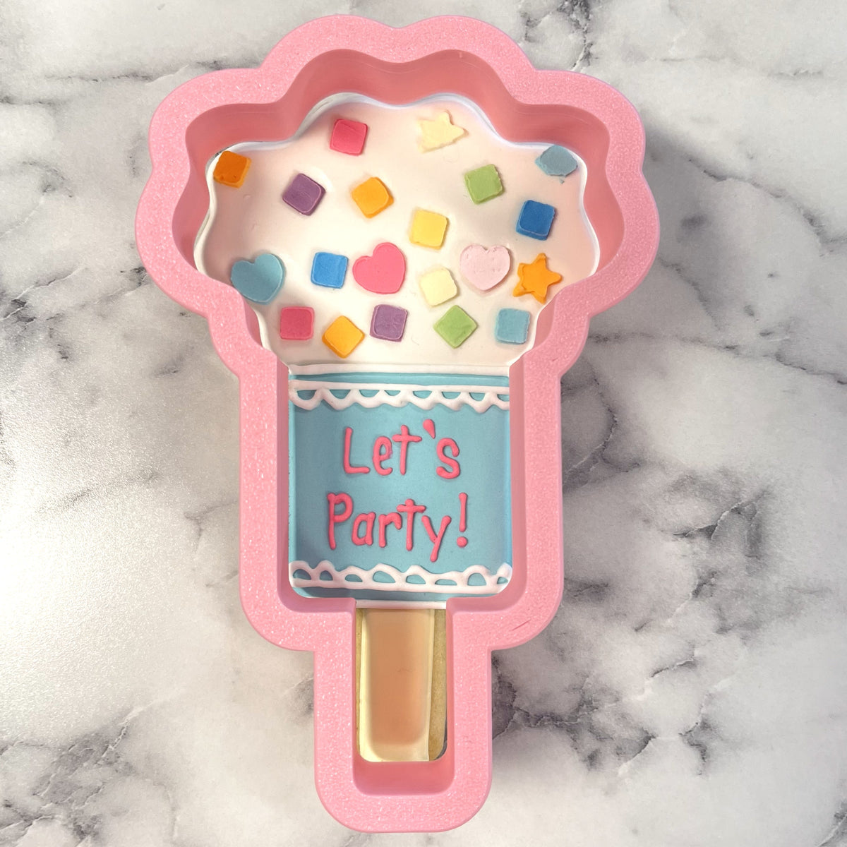 Pink silicone popsicle mold with colorful candy sprinkles and lets party label for confetti popper flour box club cookie cutter