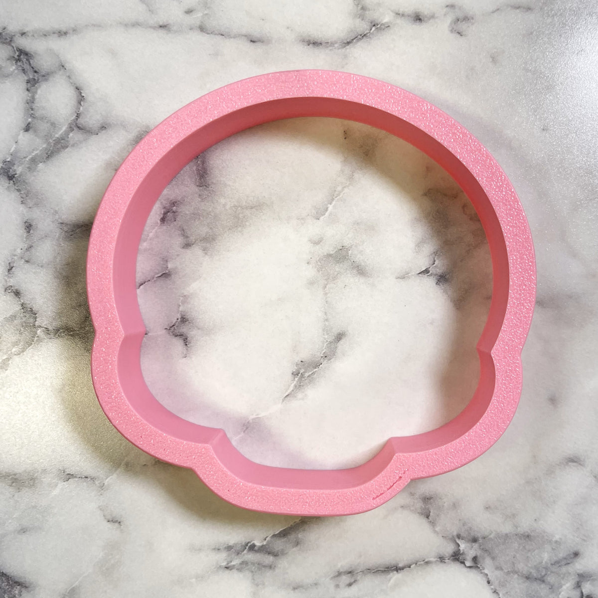 Pink glittery silicone flower shaped tray used as a cute chubby skull cookie cutter mold