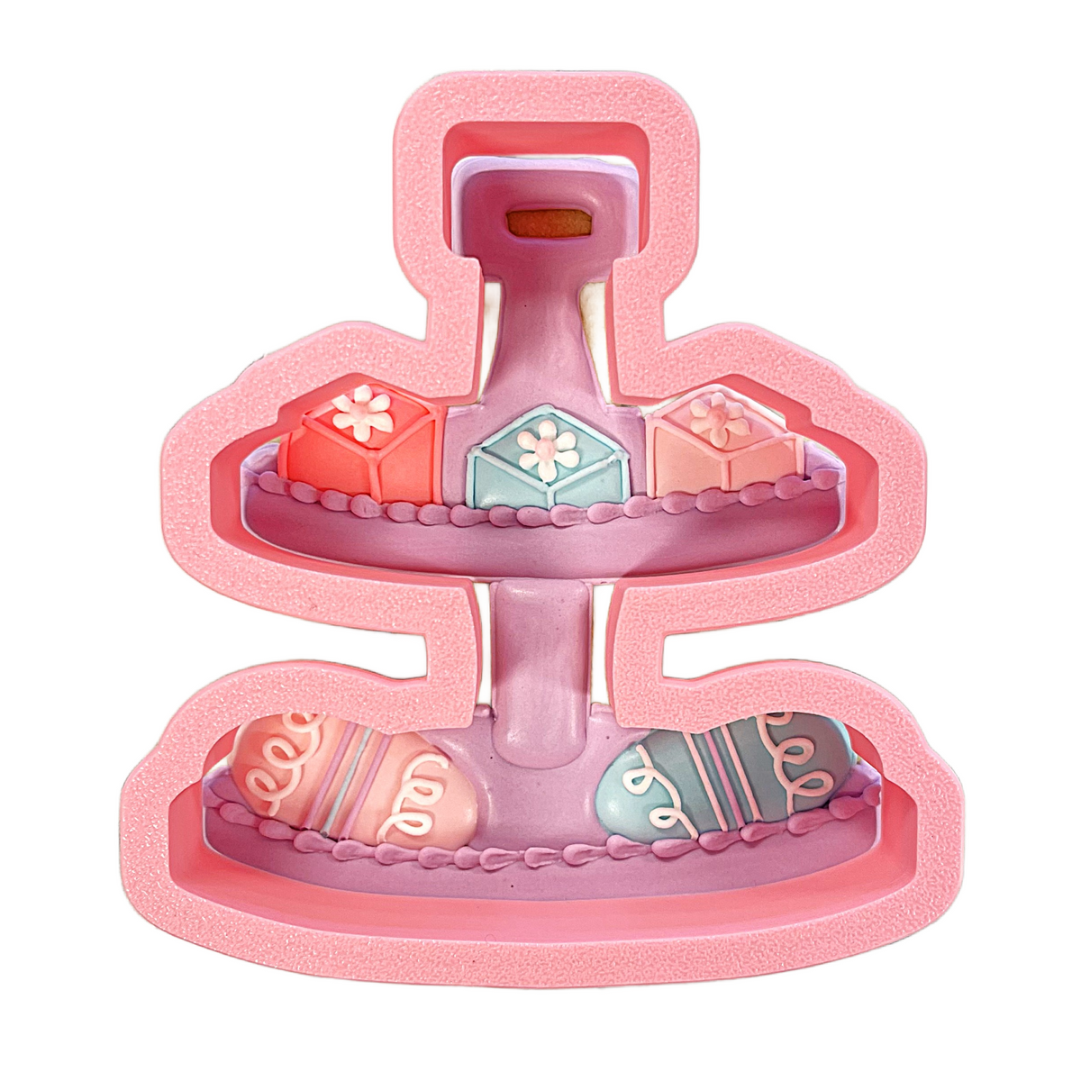 Pink two-tiered dessert stand with decorative fondant-covered pastries and eggs for cookie cutter display