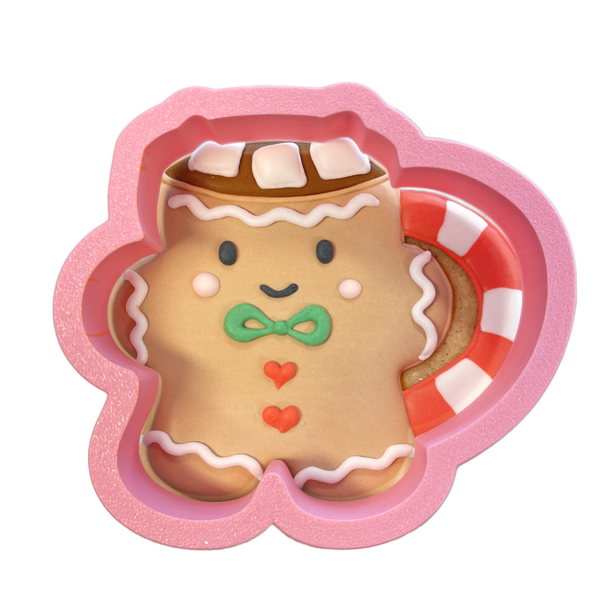 Pink silicone gingerbread mug cookie cutter with candy cane handle and white icing details for festive baking