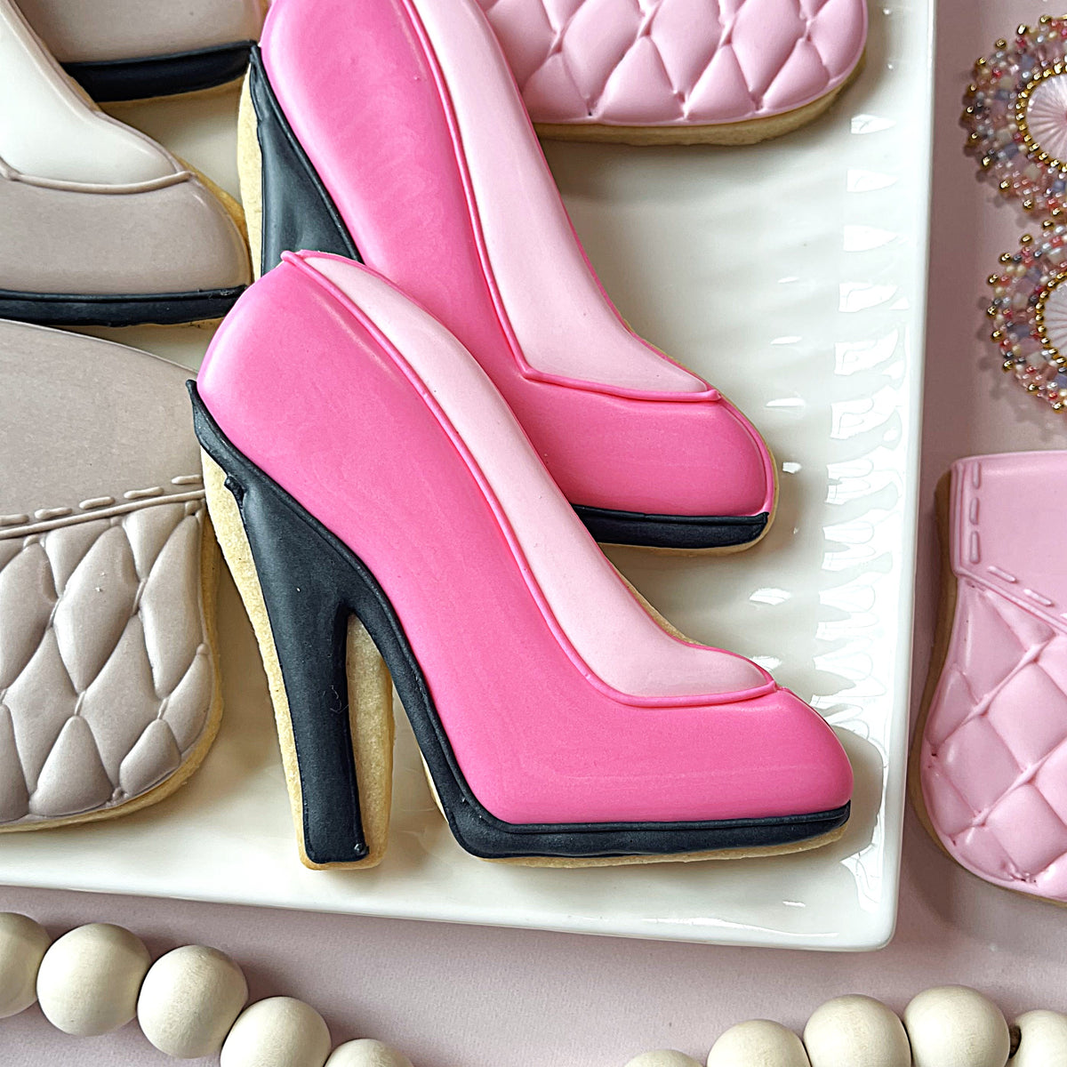 Pink high-heeled shoe cookie with black accents and glossy icing from ladies night out cookie cutter bundle
