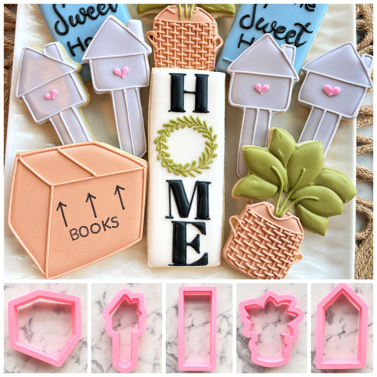 A housewarming cookie cutter set featuring intricately decorated pastel fondant sugar cookies shaped like houses and plants