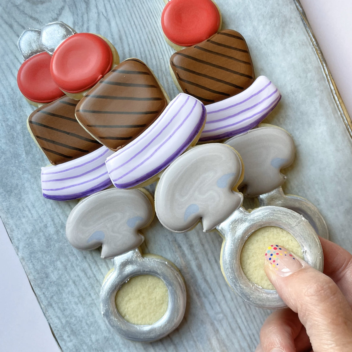 Delicate sugar cookies shaped like wedding rings with silver icing and soft yellow center made using kabob large cookie cutter