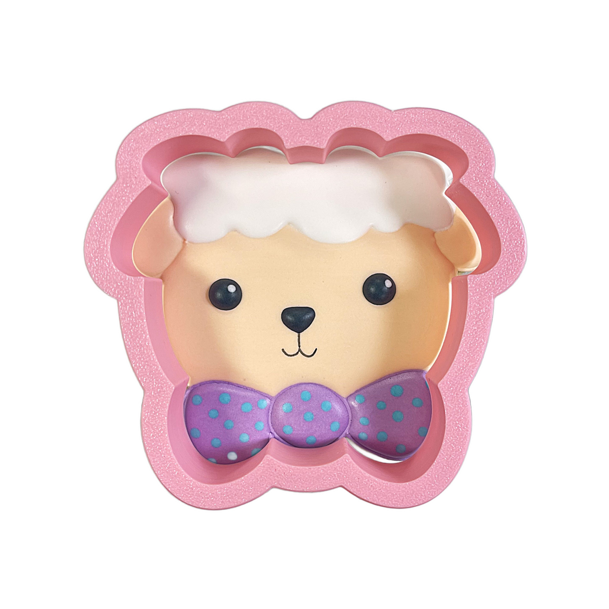 Pink glittery lamb-shaped baking mold with beige face black eyes white wool and purple polka dot bow tie for cookies