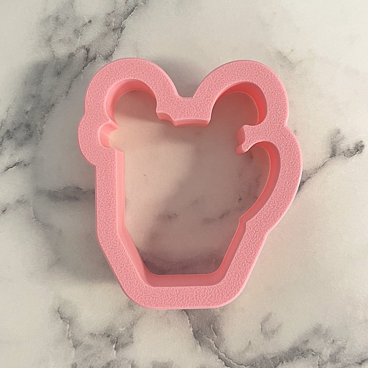 Pink silicone mini hot cocoa with candy cane cookie cutter shaped like a cupcake with two bunny ears on top