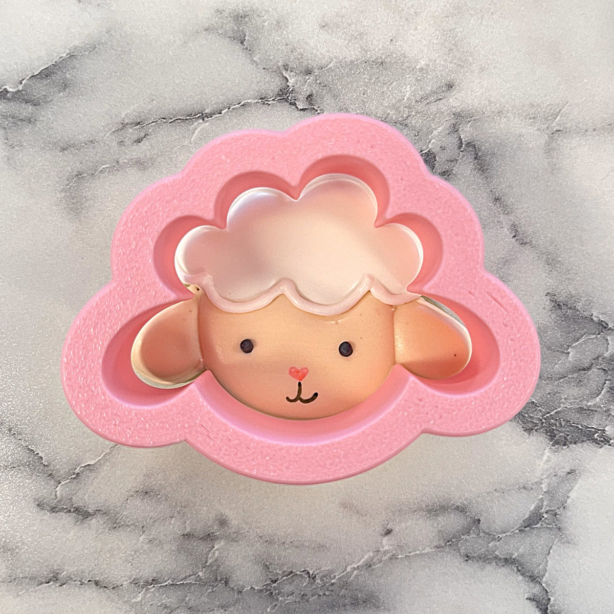 Mini lamb face cookie cutter pink silicone mold with glossy light pink wool interior and tan face with black eyes