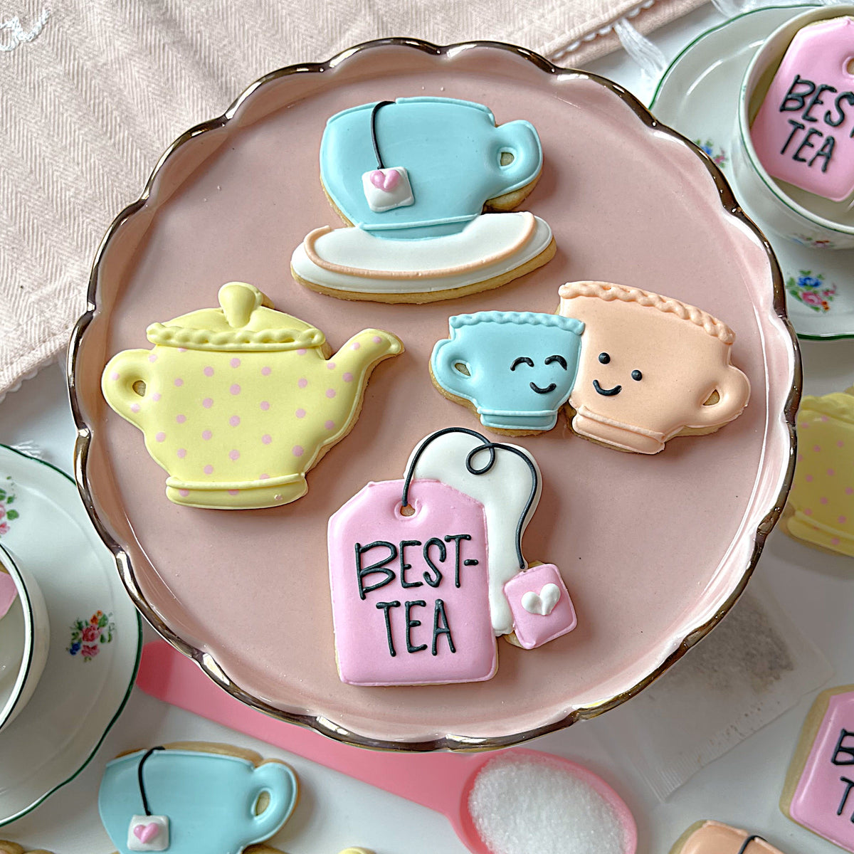 Mini teabag cookie cutter with pastel-colored teapot and tea cup sugar cookies decorated with icing details