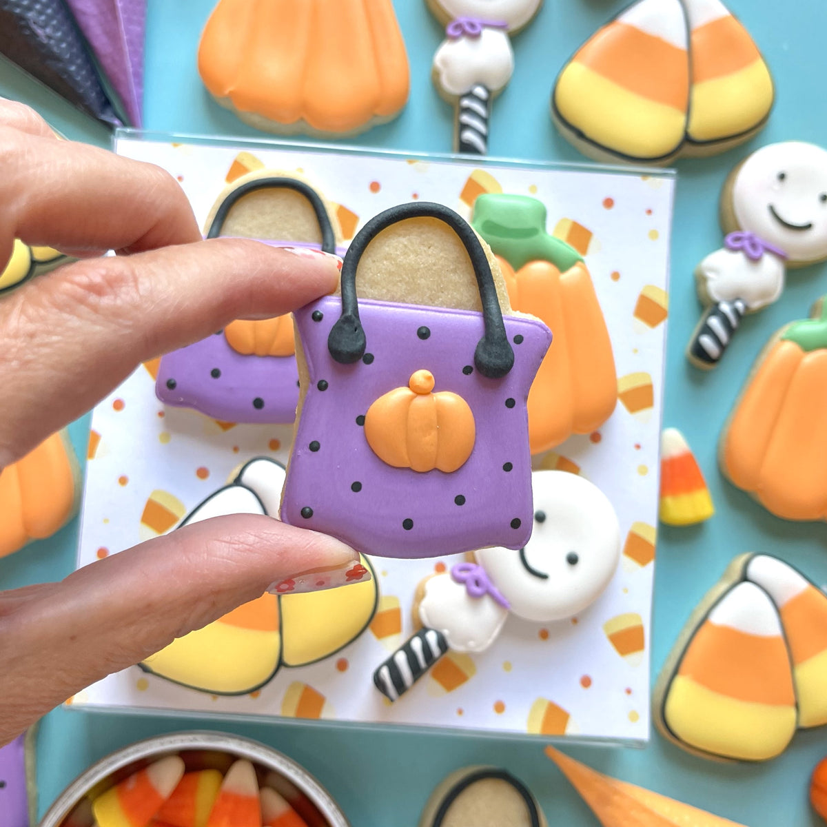 Mini halloween candy 4pc flour box club cookie cutter set featuring a purple handbag-shaped cookie with pumpkin decoration