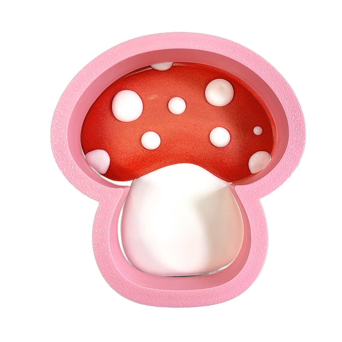 Pink mushroom-shaped silicone baking mold with red polka dot cap and smooth white stem from flour box club flip cookie cutter
