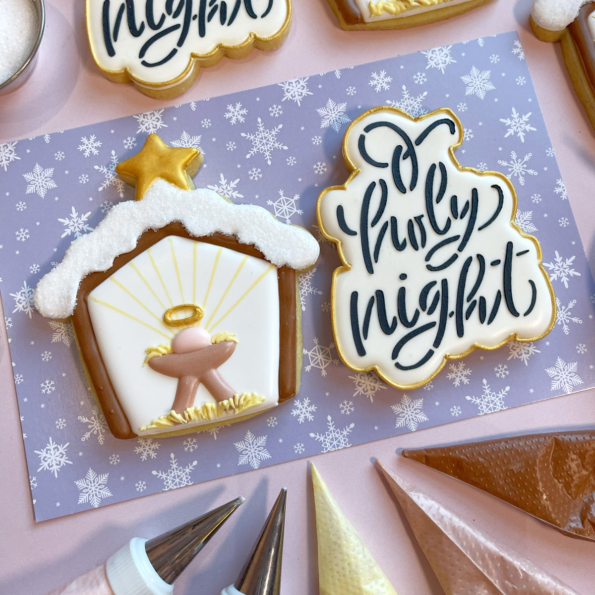 A white frosted christmas cookie shaped like a nativity stable with gold trim and a golden star made using o holy night plaque cookie cutter with stencil