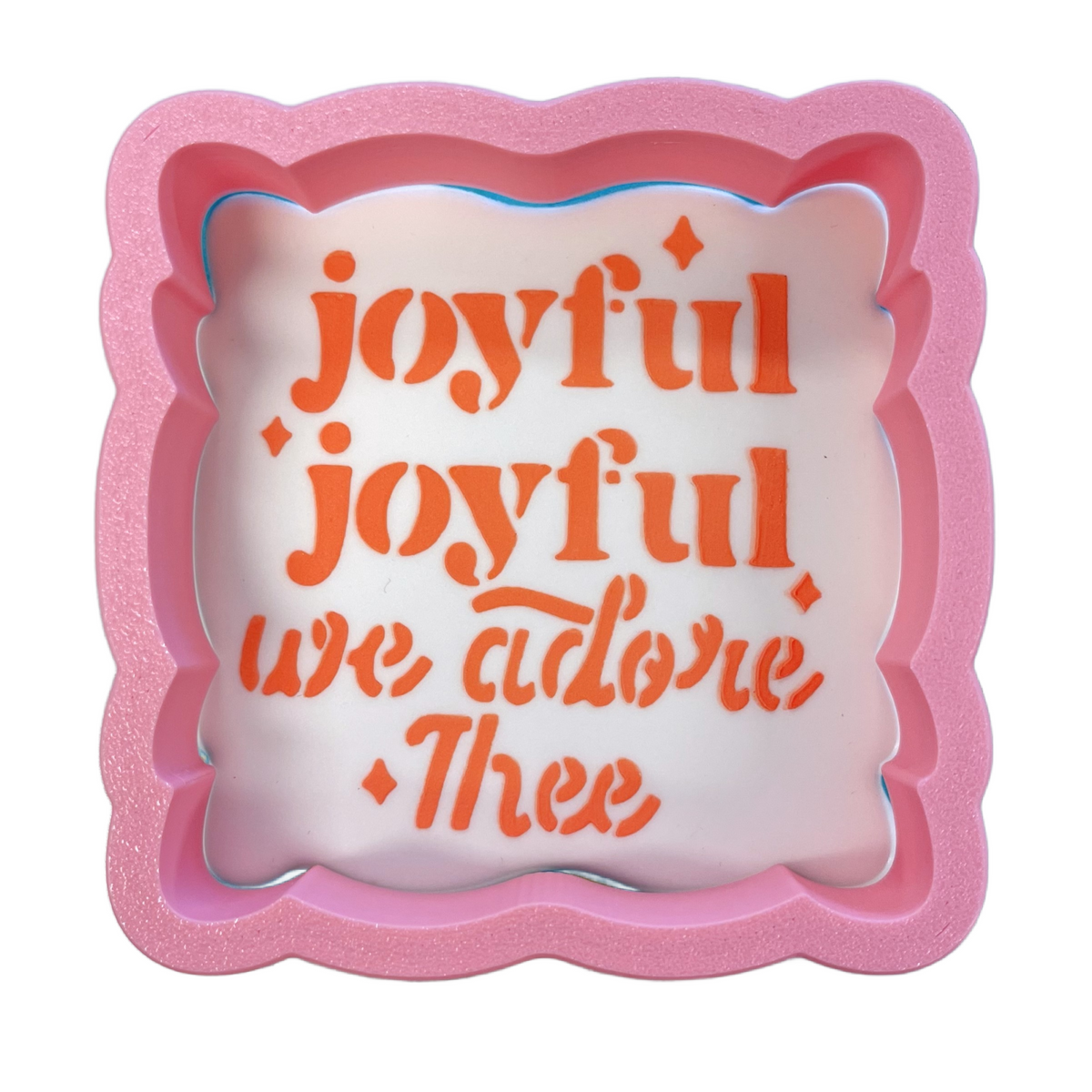 Pink glittery square plaque cookie cutter with white interior and orange cursive joyful joyful we adore thee text