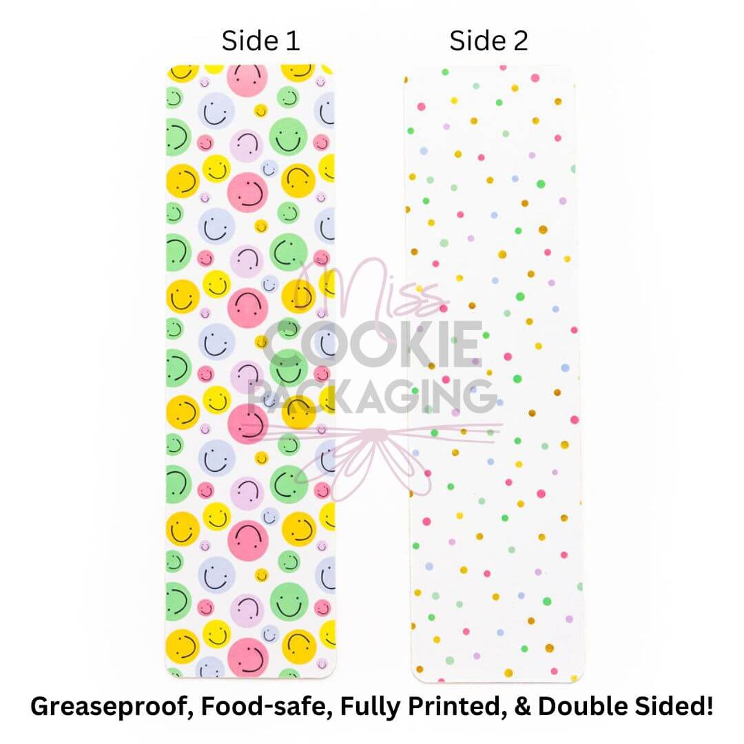 Double-sided greaseproof cookie bag backer card with colorful smiling faces on one side and multicolored polka dots on the back