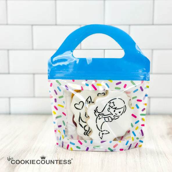 Blue-handled clear plastic sprinkle cookie bag containing white sugar cookies with black icing designs set of 10 bags