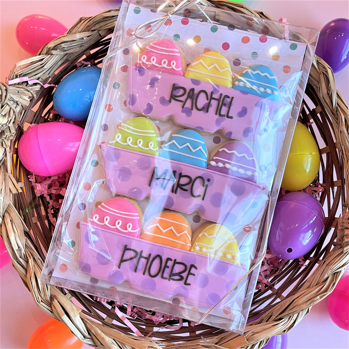5 x 8 rectangle clear cookie box with plastic-wrapped colorful easter egg-shaped cookies on purple polka dot liners
