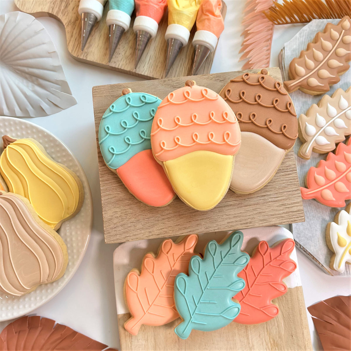 Pastel-colored acorn doodle cookies with smooth glossy icing and delicate piped details made using acorn doodle cookie cutter
