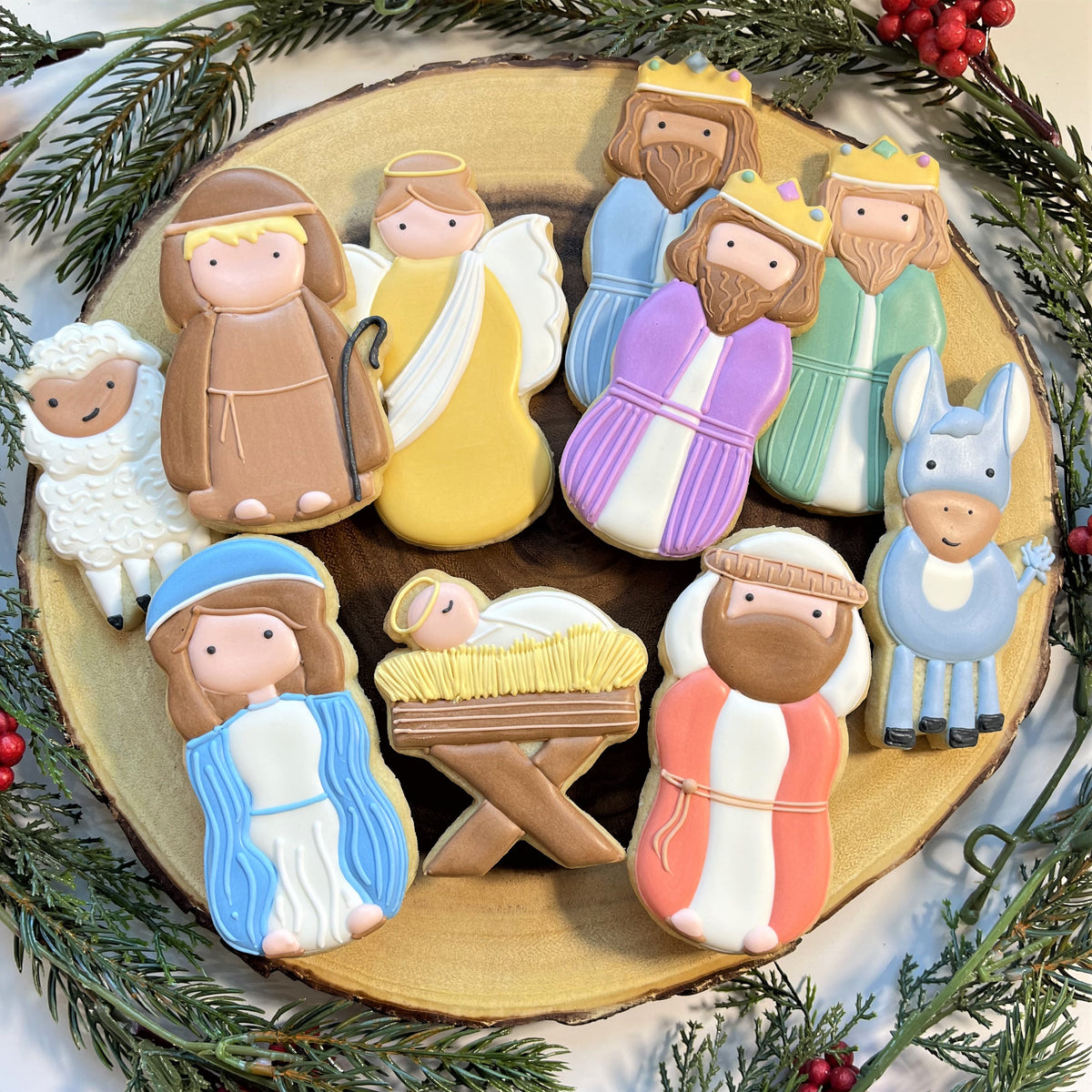 A set of intricately decorated christmas-themed sugar cookies featuring nativity figures made with baby jesus cookie cutter