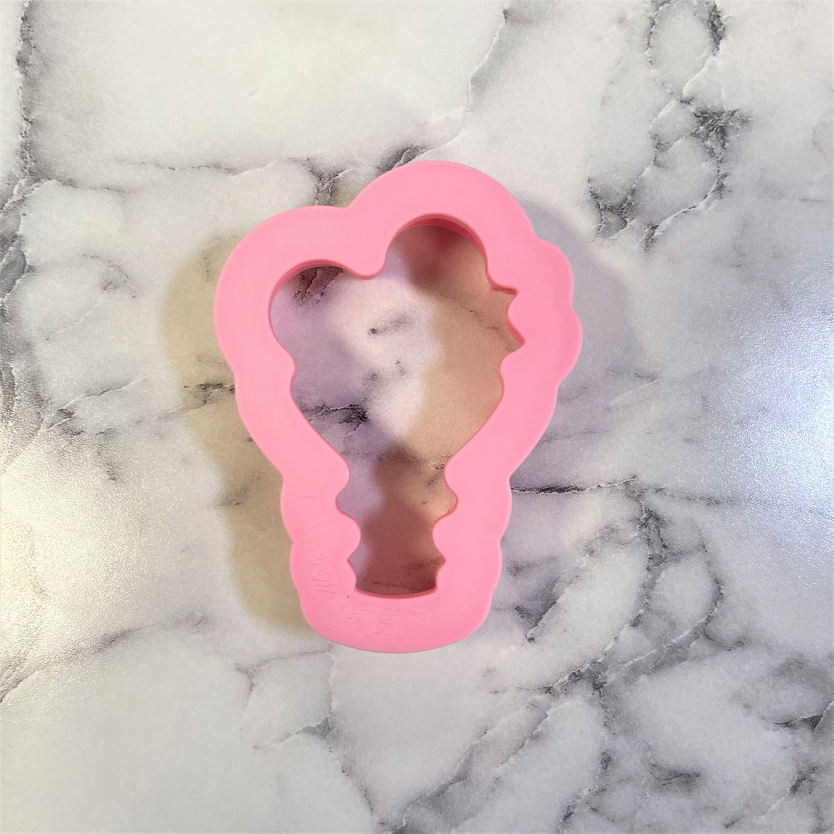 Pink silicone mini flower bouquet cookie cutter shaped like a lightbulb for baking and crafting uses